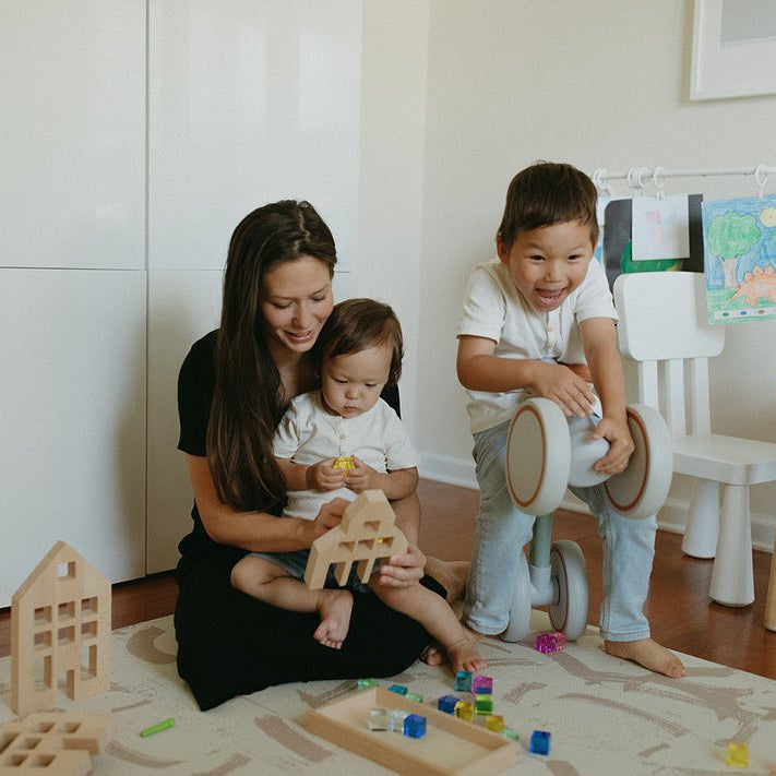 Woman and two children playing on strokes sandstorm play mats